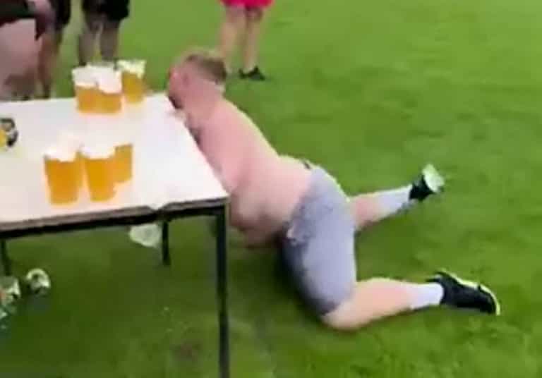 Hilarious moment rugby player taking part in beer slide challenge collides with table full of pints