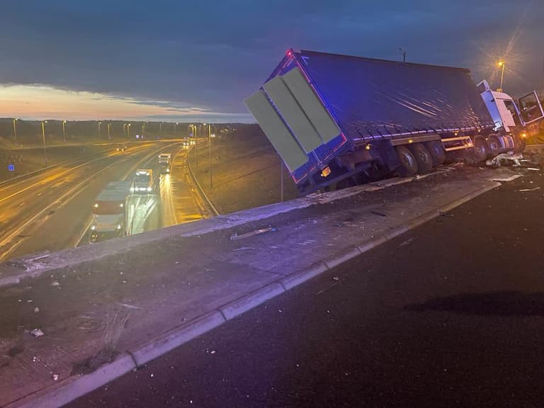 Lorry left hanging off motorway bridge after crash Lorry left hanging off motorway bridge after crash
