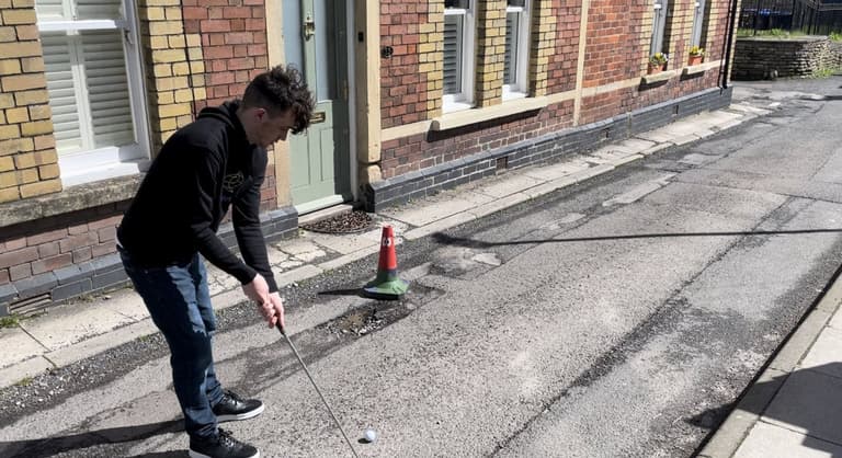Teenager has so many potholes on road that he turns it into crazy golf course Teenager has so many potholes on road that he turns it into crazy golf course