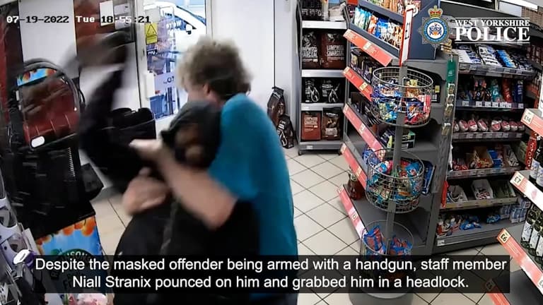 Moment Mop-wielding have-a-go-hero puts armed robber in headlock Moment Mop-wielding have-a-go-hero puts armed robber in headlock