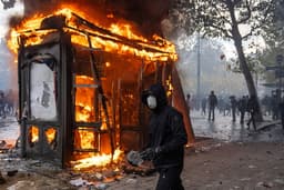 Paris riots leave cars torched and shops looted as 1,800 arrested