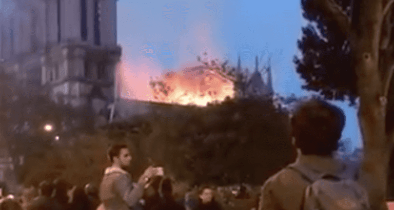 Watch Parisians sing at the feet of their burning Lady Watch Parisians sing at the feet of their burning Lady