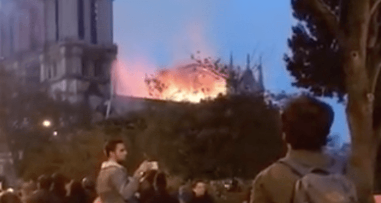 Watch Parisians sing at the feet of their burning Lady Watch Parisians sing at the feet of their burning Lady