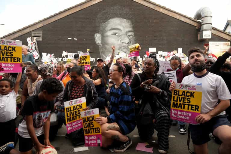 People take knee at vigil outside Rashford mural in Manchester People take knee at vigil outside Rashford mural in Manchester