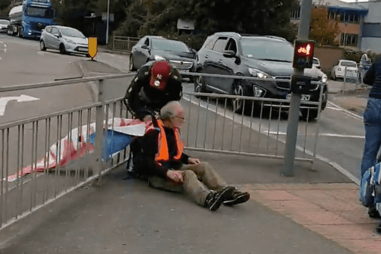 Insulate Britain protestor tied to railing with own banner by angry driver Insulate Britain protestor tied to railing with own banner by angry driver