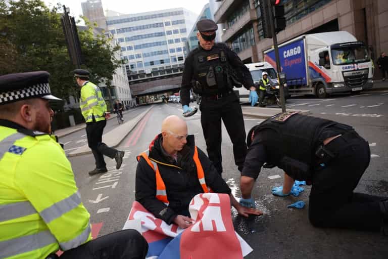 Insulate Britain protestors glue themselves to ground to prevent police arrest Insulate Britain protestors glue themselves to ground to prevent police arrest