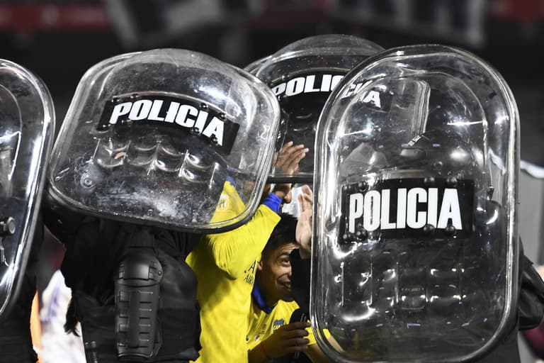 Boca Juniors players helped off pitch by riot police after Superclásico win Boca Juniors players helped off pitch by riot police after Superclásico win