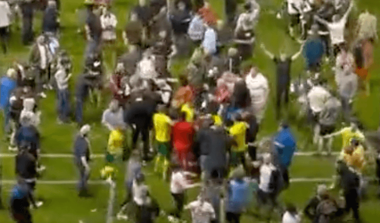 Swindon players appear to be attacked in pitch invasion following play-off defeat Swindon players appear to be attacked in pitch invasion following play-off defeat