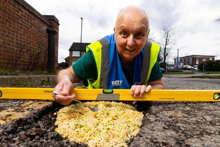 Man fills potholes with pot noodles to highlight state of UK roads Man fills potholes with pot noodles to highlight state of UK roads