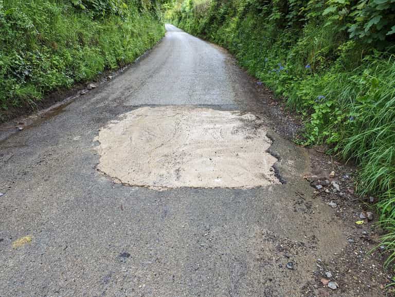 Officials search for mystery motorist who filled huge pothole with concrete Officials search for mystery motorist who filled huge pothole with concrete