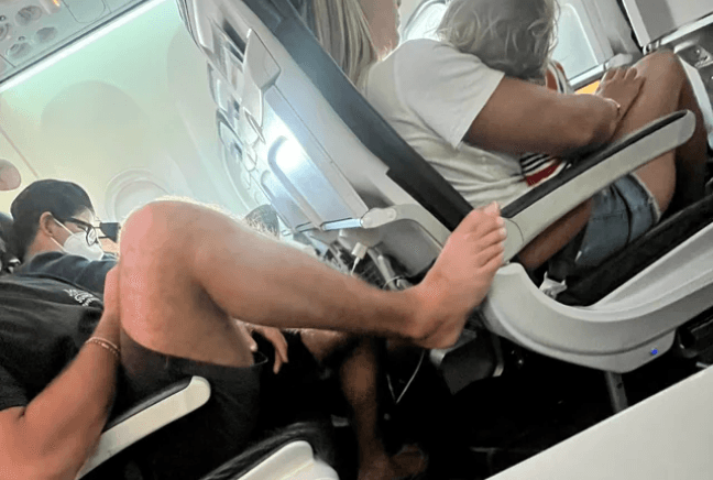 Plane passenger sparks outrage after putting his bare foot on armrest in front Plane passenger sparks outrage after putting his bare foot on armrest in front