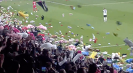 Besiktas and Antalyaspor fans throw stuffed toys onto pitch for earthquake victims